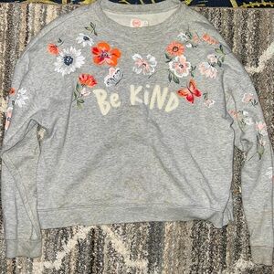 This is a Wondernation be kind sweater with florals.